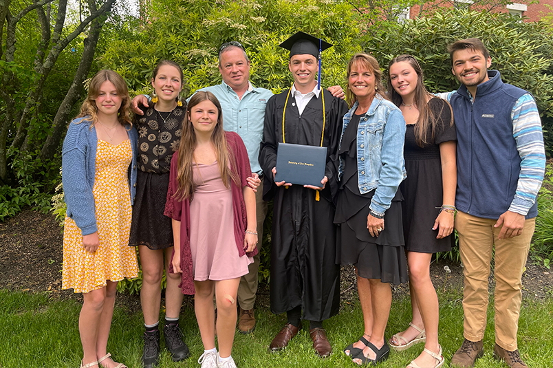 Photo of Longval family outside. Order from left to right, Grace, Samantha, Joy, David, Noah, Dawn, Hannah, and Caleb.